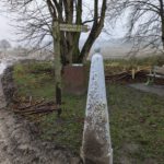 Een richtingaanwijzer en een grenspaal